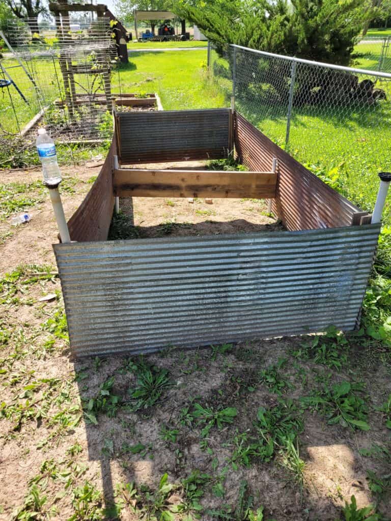 a raised garden bed made from metal barn siding in a long rectangular shape