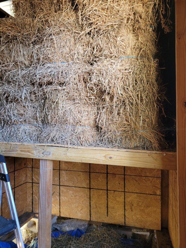 square hay bales sitting in a hay loft